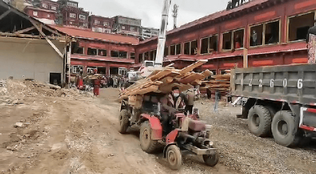 Photographs from the demolition, Tibetans can be seen removing building materials by hand, alongside others using machinery