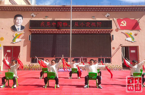 ''I am a Chinese baby, I love the motherland since my childhood'' is the wording on a LED placard between an image of Xi Jinping and a Chinese flag. Image: Ganzi Daily state media, 10 May 2022.